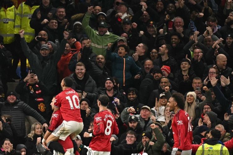 Diogo Dalot dikerumuni oleh rekan satu timnya setelah mencetak gol pembuka dalam pertandingan sepak bola Liga Inggris antara Manchester United vs West Ham United di Old Trafford di Manchester, barat laut Inggris, pada 4 Desember 2025. (Foto oleh Oli SCARFF / AFP) 