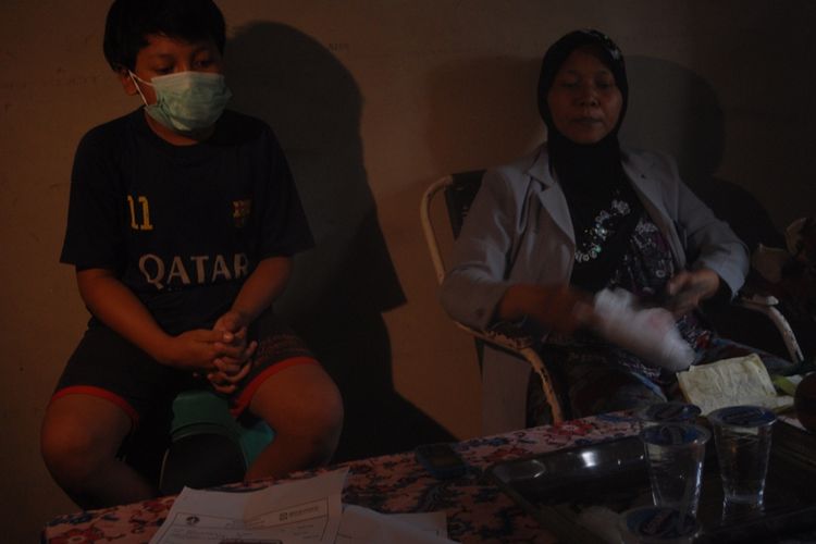 Masrikah (49) dan putranya RS (12) saat berbincang dengan Kompas.com di rumahnya di Kelurahan Wirosari, Kecamatan Wirosari, Kabupaten Grobogan, Jawa Tengah, Selasa (8/10/2019) sore.