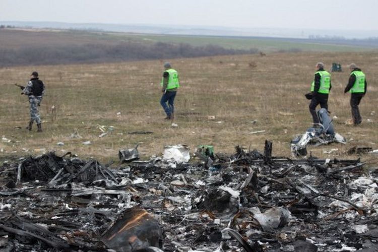 Dalam foto yang diambil pada 11 November 2014 ini, penyelidik Belanda didampingi oleh pemberontak bersenjata pro-Rusia tiba di dekat puing-puing Malaysia Airlines MH17, di lokasi kecelakaan dekat desa Grabove, timur Ukraina. MH17 jatuh menewaskan 298 orang di wilayah terpencil yang dikuasai pemberontak di timur Donetsk.