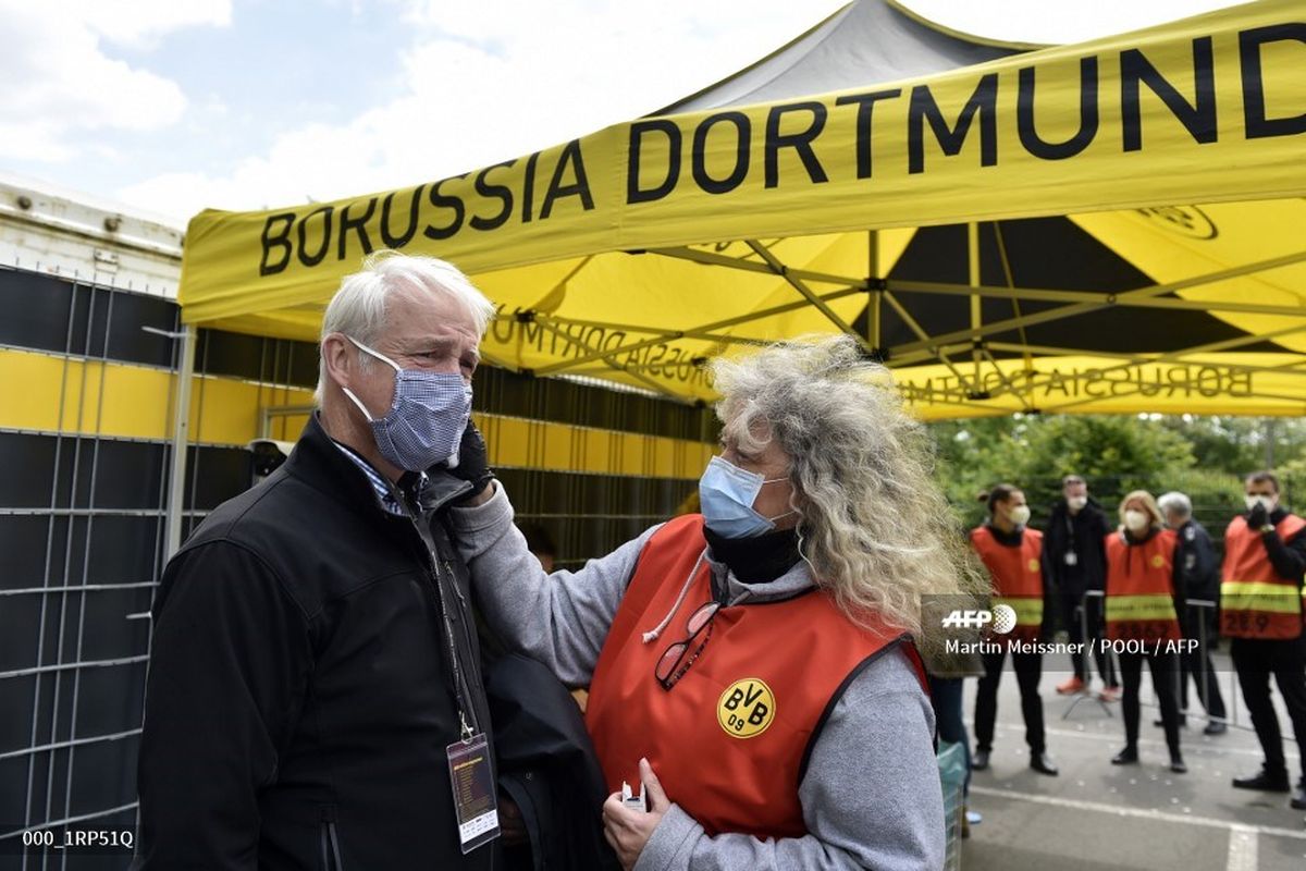 Seorang kru televisi diperiksa temperaturnya saat hendak memasuki stadion Signal Iduna Park untuk meliput laga Borussia Dortmund vs Schalke pada 16 Mei 2020.