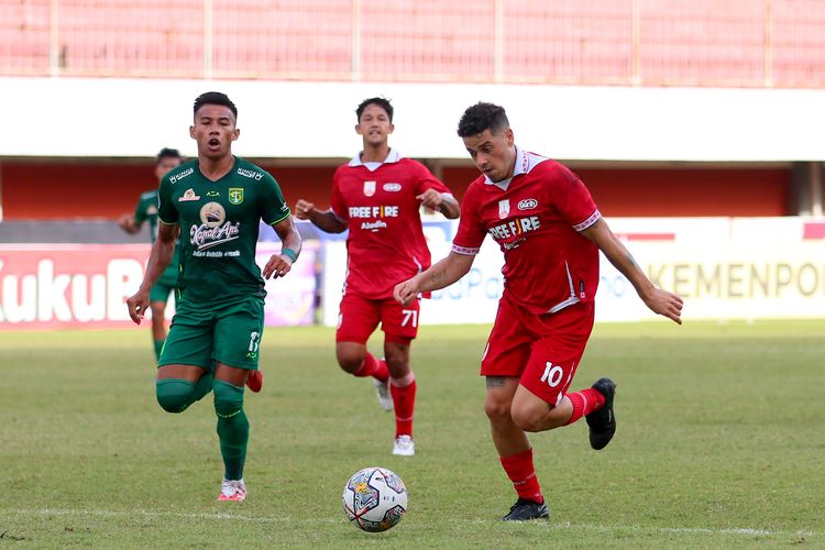 Pemain Persis Solo Alexis Messidoro menggiring bola dijaga pemain Persebaya Surabaya Ahmad Nufiandani saat pertandingan pekan ke-16 Liga 1 2022-2023 yang berakhir dengan skor 0-0 di Stadion Maguwoharjo Sleman, Rabu (21/12/2022) sore.