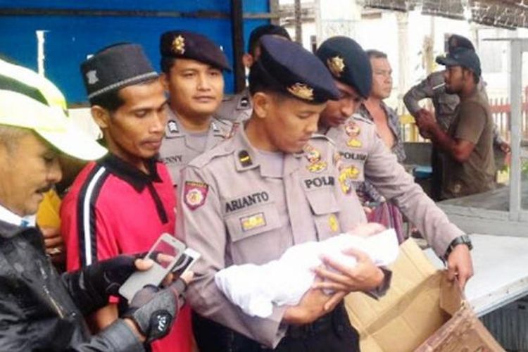 Polisi menggendong bayi yang ditemukan dalam kardus Desa Alu Bate, Kecamatan Peudawa, Aceh Timur, Rabu (8/2/2017)