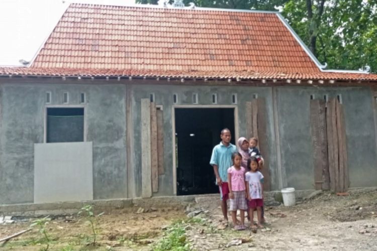 Sri Hartutik dengan suami dan ke 3 anaknya didepan rumah bantuan dari Pemerintah Daerah Kabupaten Ngawi.