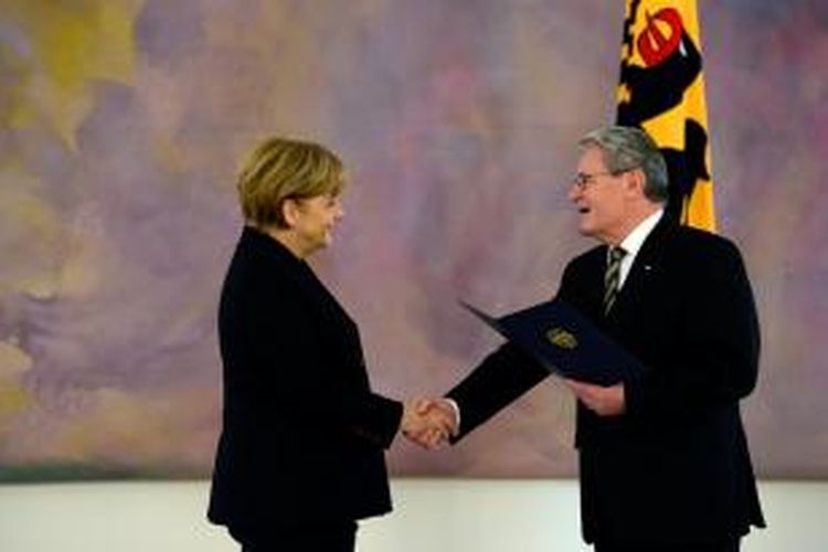 Presiden Jerman Joachim Gauck menjabat tangan Angela Merkel dalam seremoni penyerahan sertifikat terpilihnya Merkel sebagai kanselir untuk masa jabatan ketiga, Senin (17/12/2013) di Istana Bellevue, Berlin.