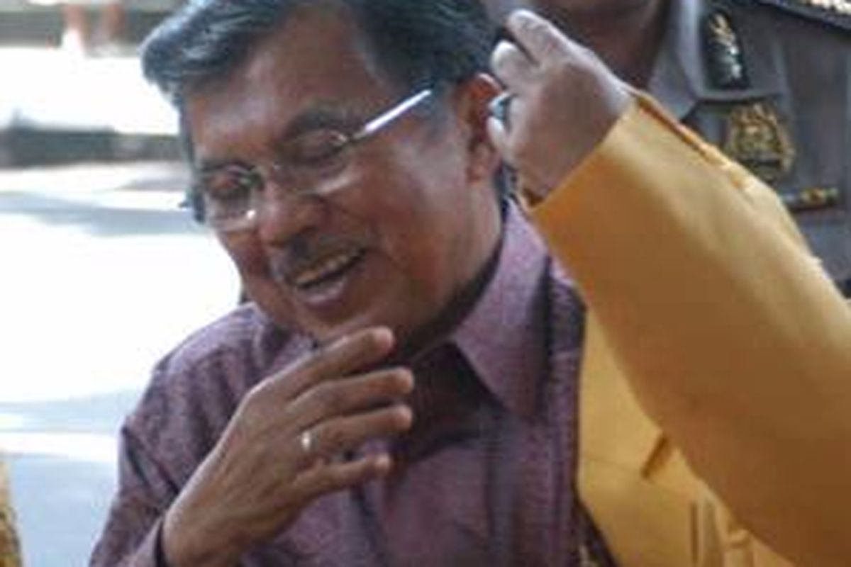 Wapres Jusuf Kalla memakai jas Golkar sebelum menghadiri acara temu kader partai Golkar di Denpasar, Bali, Minggu  (17/2). Acara temu kader dilakukan di sela-sela kunjungan kerjanya untuk menggalang dukungan bagi calon gubernur Bali dari Golkar.