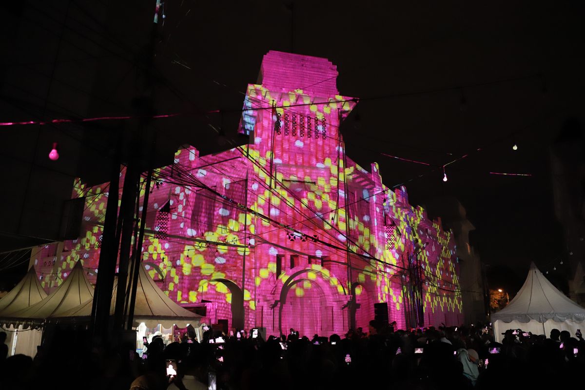 Warga Kota Medan antusias menyaksikan pertunjukan maping visual di Gedung Warenhuis sebagai tanda dibukanya kembali Kesawan City Walk, Medan, Sumut, Jumat (19/11/2021).