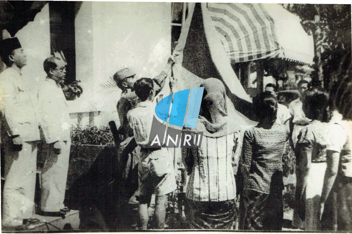 Pengibaran bendera merah putih usai pembacaan naskah teks proklamasi kemerdekaan Republik Indonesia di rumah Soekarno di Jalan Pegangsaan Timur Nomor 56, Jakarta (sekarang Jalan Proklamasi Nomor 5, Jakarta Pusat) pada 17 Agustus 1945.