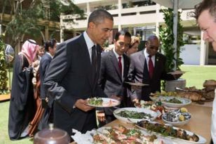 Presiden Barack Obama terlihat sedang mengambil makanan dalam jamuan ala barbeque yang digelar di sela-sela KTT G-20 di Brisbane, Australia.