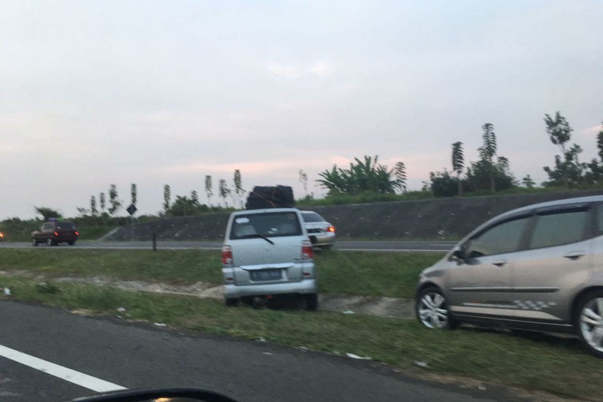 Pemudik menyeberangi parit untuk pindah ke jalur sebelahnya di ruas tol Cipali setelah seluruh ruas jalan di tol ini digunakan untuk kendaraan arah ke Jakarta, Sabtu (1/7/2017) petang.