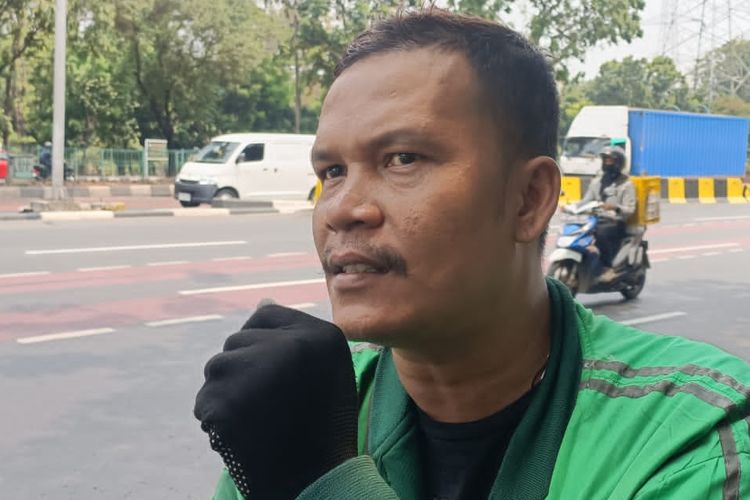 Rodinihari (36) Ojol, saat di temui okeh kompas.com di depan kampus UKI, Cawang, Jakarta Timur, Rabu (11/10/2023).