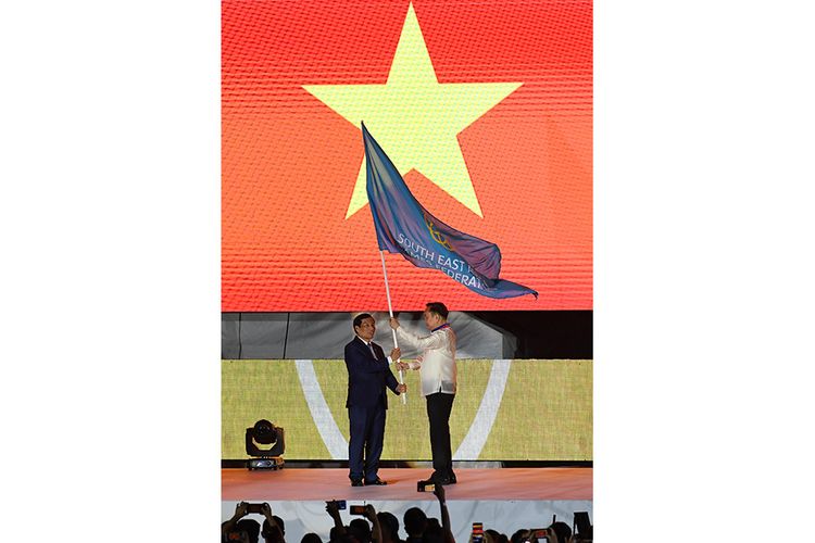 Presiden Komite Olimpiade Filipina, Abraham Tolentino (kanan) menyerahkan bendera SEA Games kepada Menteri Olahraga, Budaya dan Pariwisata Vietnam Nguyen Ngoc Thien saat serah terima panitia penyelenggara di sela upacara penutupan SEA Games ke-30 di Stadion Atletik New Clark, Filipina, Rabu (11/12/2019). SEA Games ke-30 di Filipina resmi ditutup dan akan digelar kembali di Vietnam pada 2021.
