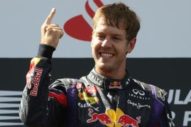 Pebalap Red Bull, Sebastian Vettel, merayakan kemenangannya pada GP Jerman, di atas podium Sirkuit Nurburgring, Minggu (7/7/2013).