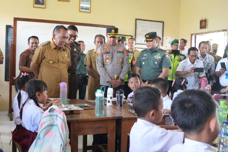 Bupati Jembrana I Nengah Tamba bersama Komandan Kodim 1617/Jembrana Letkol Inf M. Adriansyah dan Kapolres Jembrana AKBP Endang Tri Purwanto mengecek pendistribusian makanan tahap awal Program Makan Bergizi Gratis di SD 1 Banjar Tengah, Jembrana, Bali, Selasa (31/12/2024).