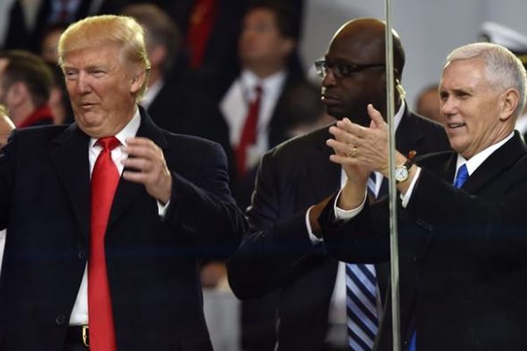 Presiden AS Donald Trump didampingi wakil presiden Mike Pence menyaksikan parade kehormatan usai dilantik di Washington DC, Jumat (20/1/2017).