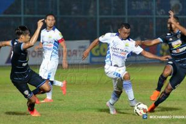 Gelandang Persib Bandung, Firman Utina, coba menghindar dari adangan dua pemain Arema Cronus.