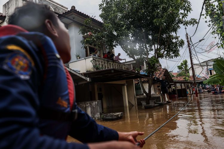 Anggota Suku Dinas Penanggulangan Kebakaran dan Penyelamatan mengevakuasi warga di Jalan Masjid Al Makmur Gang Buntu RT 017/07, Pejaten Timur, Pasar Minggu, Jakarta Selatan, Senin (8/2/2021). Banjir setinggi 30-150 cm yang melanda tiga RW di Pejaten Timur itu disebabkan oleh luapan air Sungai Ciliwung.