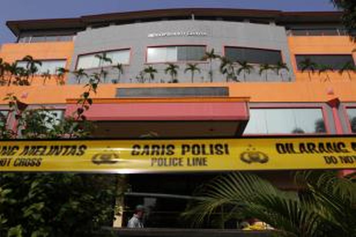 Garis polisi terpasang di tempat terjadinya ledakan di Gedung Multi Piranti Graha, Duren Sawit, Jakarta Timur, Senin (16/11/2015). Ledakan yang menghancurkan kaca depan gedung dan melukai seorang penjaga keamanan ini diduga berasal dari granat tangan.