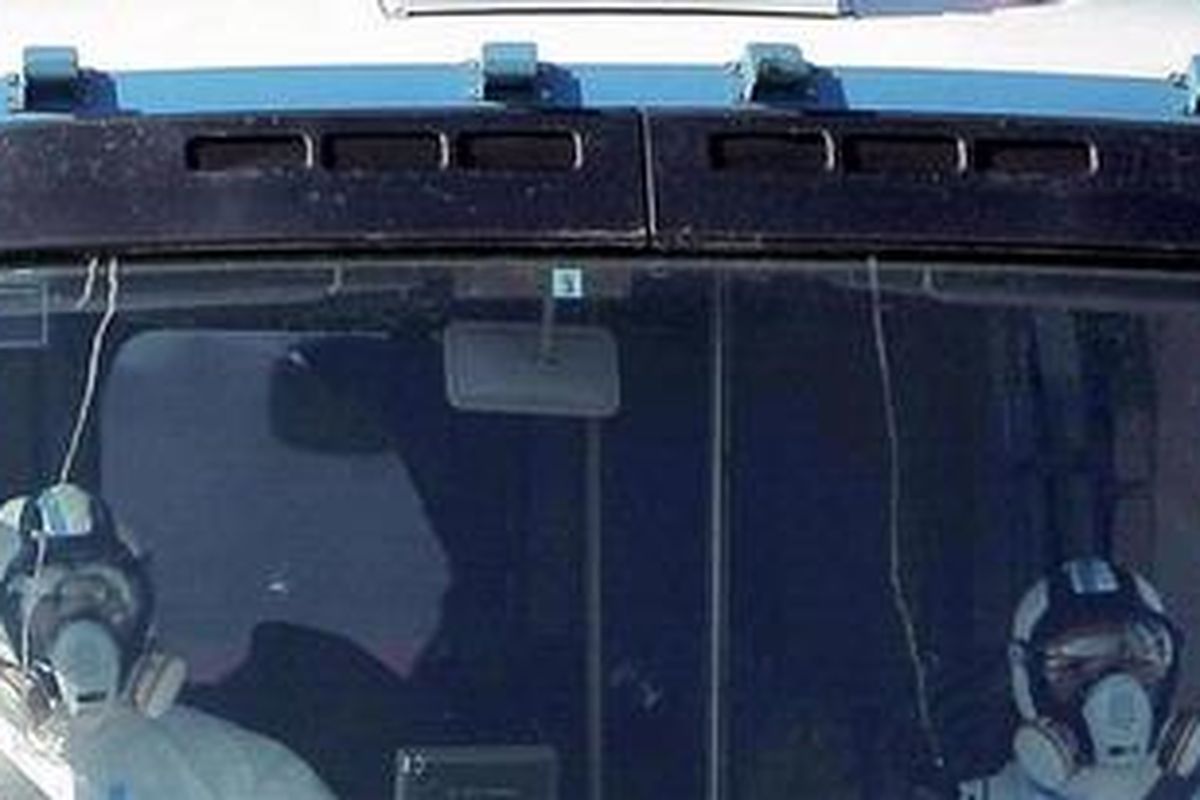 Para petugas mengenakan pakaian pelindung saat menuju ke pembangkit nuklir Fukushima yang sistem pendinginnya rusak akibat terjangan tsunami.