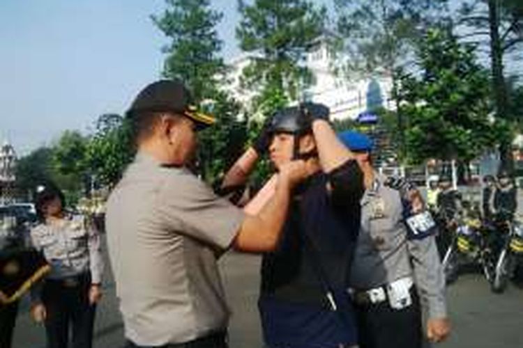 Kapolrestabes Bandung Kombes Pol Winarto saat memasangkan helm kepada tim khusus kejahatan jalanan di Mapolrestabes Bandung, Rabu (22/6/2016)