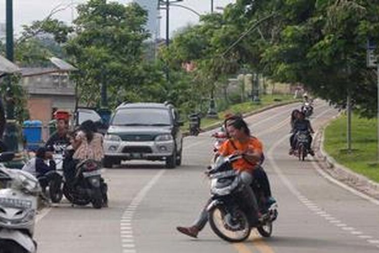 Jalur sepeda di Banjir Kanal Timur tampak masih digunakan tidak hanya motor namun juga mobil yang bahkan parkir di lokasi parkir sepeda, Jakarta, Minggu (6/1/2013). Sebelumnya jalur sepeda ini rencananya akan ditertibkan dengan melakukan razia terhadap kendaraan bermotor yang melintas.
