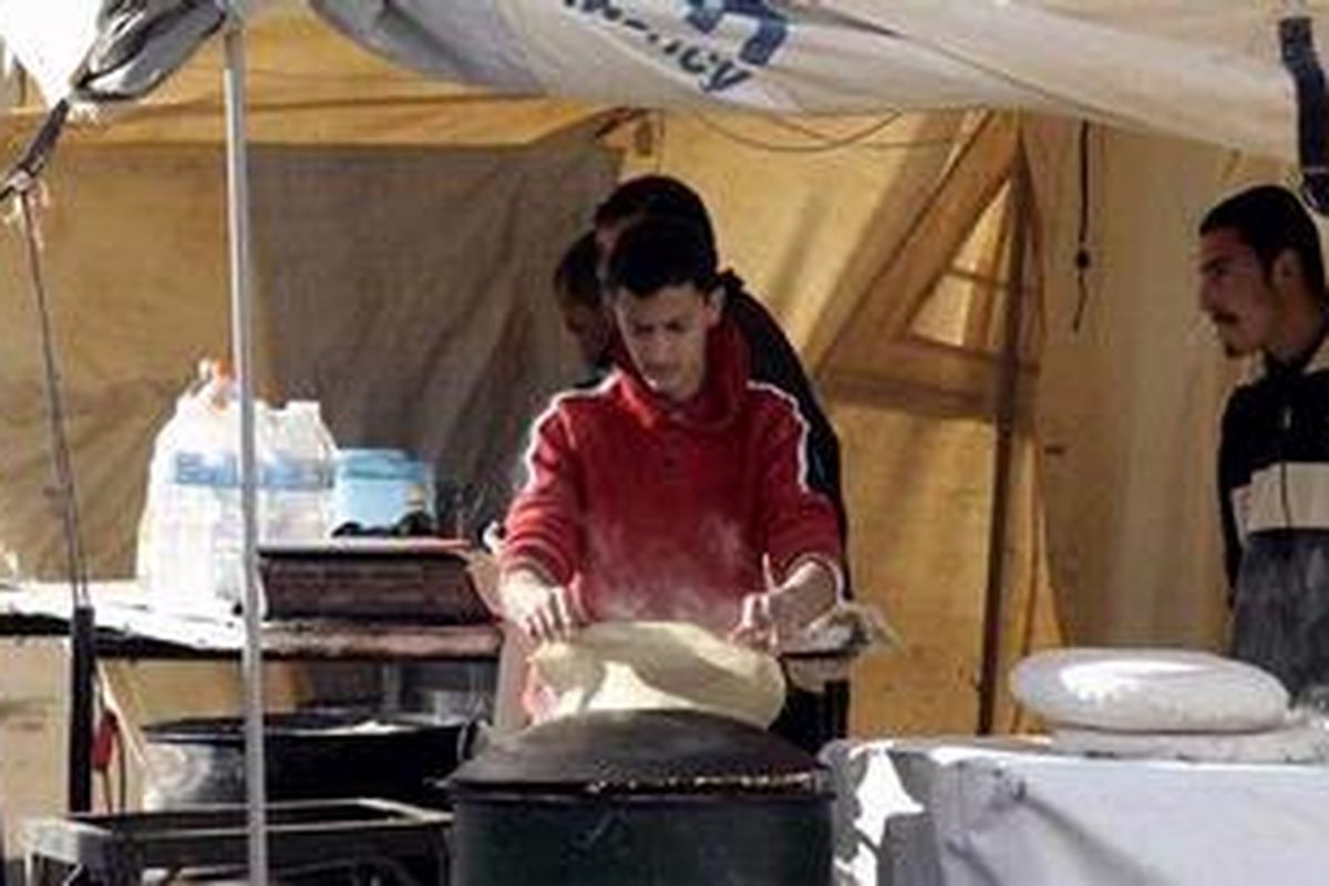 Seorang pengungsi Suriah di kamp pengungsian Zaatari dekat perbatasan dengan Jordania tengah membuat roti. Badan Pangan Dunia (WFP) memperkirakan satu juta warga Suriah kini menderita kelaparan akibat konflik bersenjata yang tak kunjung usai.