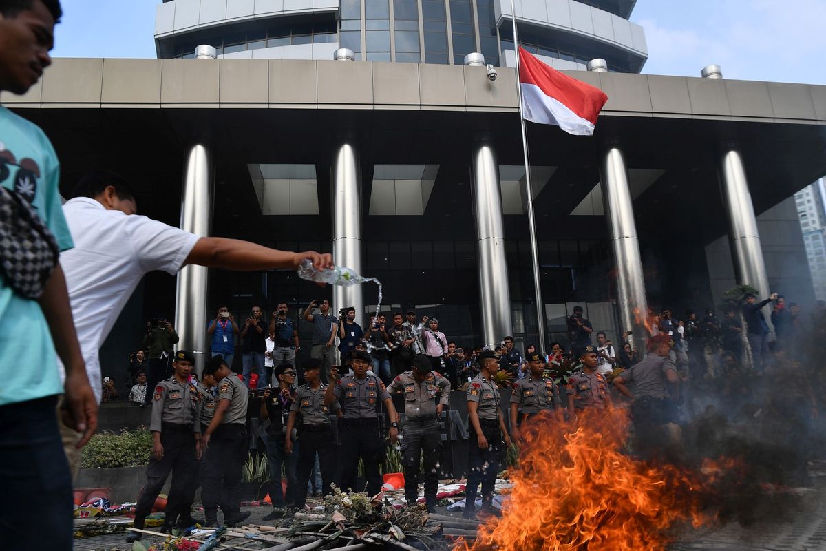 Polisi berjaga saat berlangsung unjuk rasa berujung ricuh yang dilakukan sejumlah orang tergabung dalam Aliansi Mahasiswa dan Pemuda Relawan Cinta NKRI di kantor KPK, Jakarta, Jumat (13/9/2019).