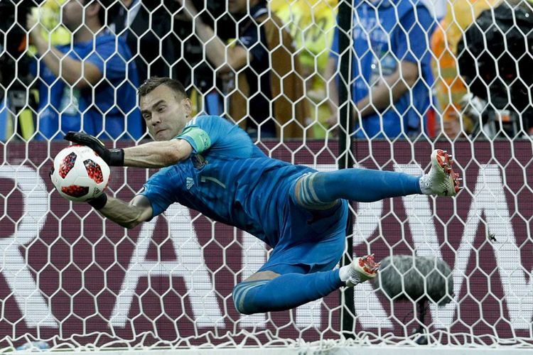 Kiper Russia Igor Akinfeev berhasil menangkap bola saat adu penalti pada laga 16 besar Piala Dunia 2018 melawan Spanyol di Stadion Luzhniki, Minggu (1/7/2018). Timnas Rusia lolos ke babak perempat final setelah menyingkirkan Spanyol lewat drama adu penalti dengan skor 4-3.