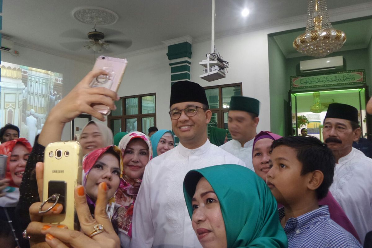 Gubernur terpilih DKI Jakarta Anies Baswedan bersama warga saat hadir dalam acara halal bihalal di Klender, Minggu (2/7/2017). 