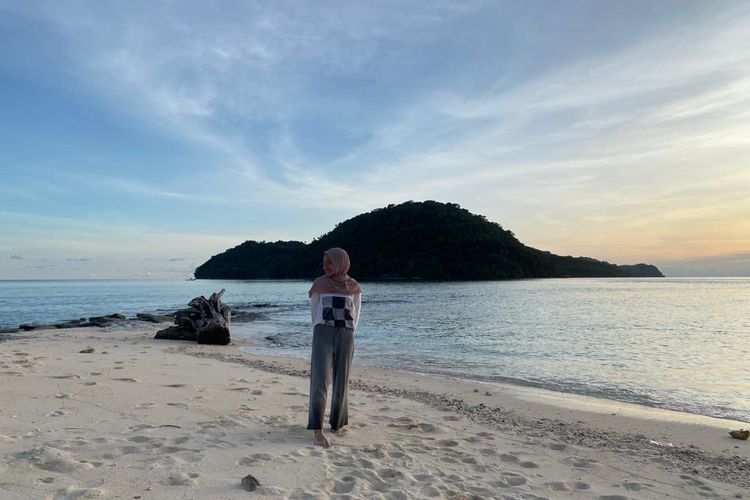 Berpose di pinggir pantai Pulau Nailaka, dengan latar belakang Pulau Rhun. Jika air sedang surut, ada jalan berupa pasir yang menghubungkan kedua pulau ini. 