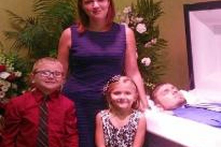 Eva Holland bersama dua anaknya berfoto di samping peti mati suaminya yang meninggal karena overdosis heroin.