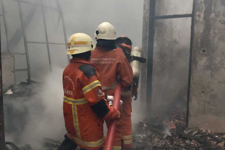 Petugas pemadam kebakaran saat memadamkan api yang menghanguskan rumah warga di Surabaya, Jumat (16/9/2022).