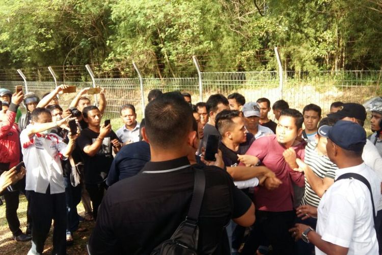 Petugas kepolisian saat mengamankan pengacara Neno Warisman, Mursal Fadillah (baju merah) di gerbang Bandara SSK II Pekanbaru, Riau, Sabtu (25/8/2018).
