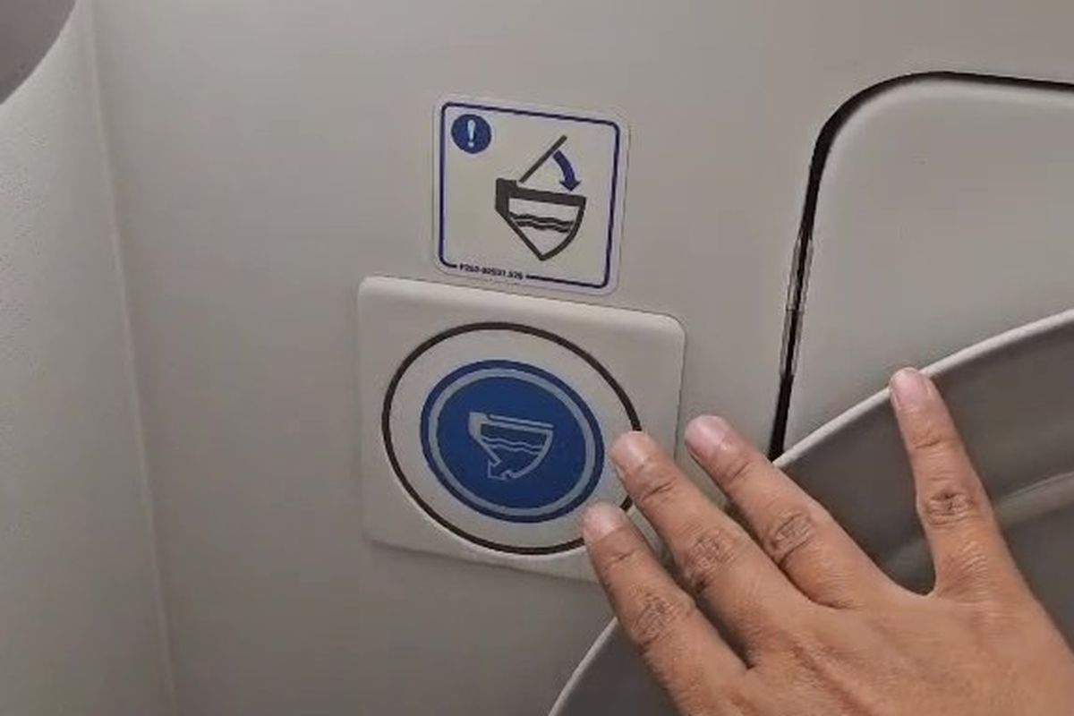 Tekan tombol flush setelah buang air di toilet pesawat.