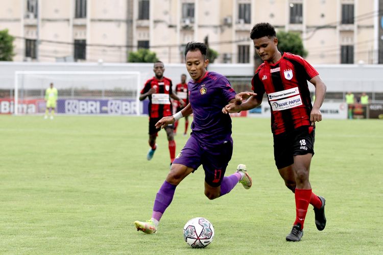 Pemain muda Persipura Jayapura David Rumakiek dijaga ketat pemain Persik Kediri Antoni Putro saat pertandingan pekan 24 Liga 1 2021-2022 yang berakhir dengan skor 0-0 di Stadion Kompyang Sujana Denpasar, Kamis (10/2/2022) sore.