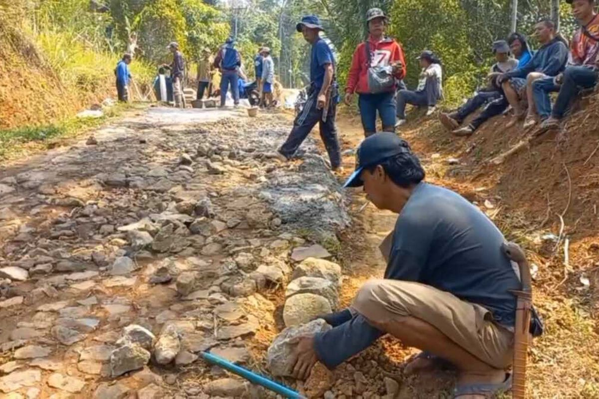 Warga kampung terpencil di Kedusunan Linggamanik Desa Bojongkapol Kecamatan Bojonggambir Kabupaten Tasikmalaya, Jawa Barat, sedang swadaya memperbaiki jalan desa yang rusak pakai biaya masyarakat sendiri secara urunan pada Kamis (12/10/2023).
