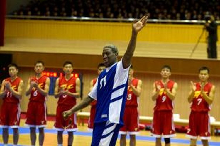 Mantan bintang basket NBA, Dennis Rodman melambaikan tangannnya ke arah pemimpin Korea Utara Kim Jong Un yang duduk di tribun kehormatan usai menyanyikan lagu 