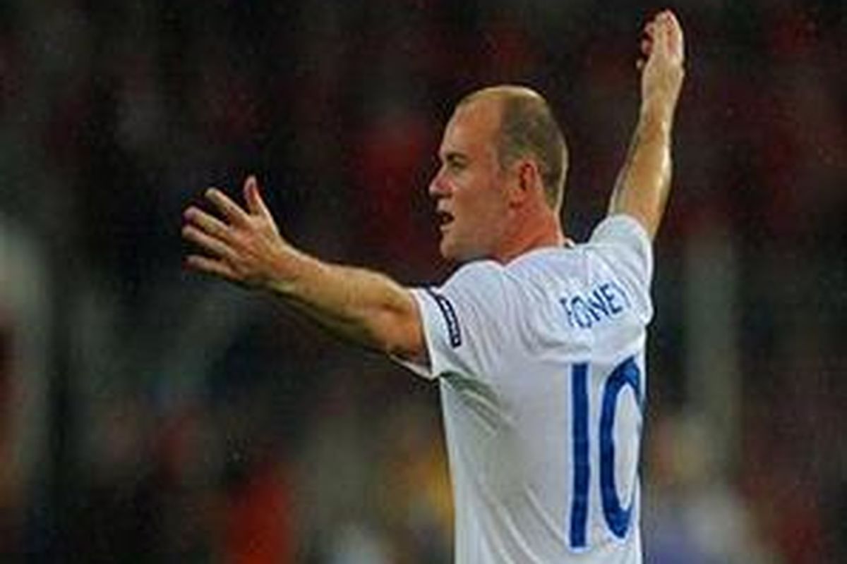 Wayne Rooney mengepakkan tangannya setelah mencetak gol ke gawang Swiss.