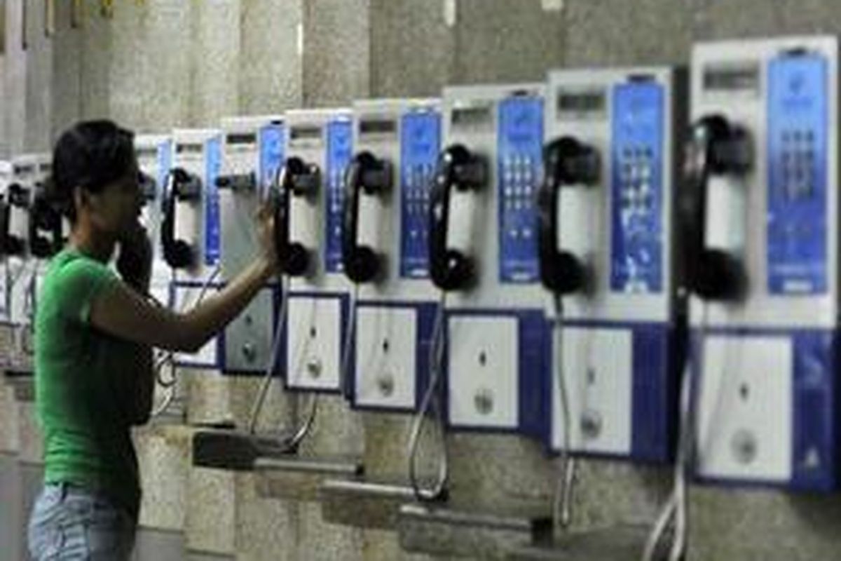 Seorang pengunjung menggunakan telepon umum milik PT Telkom di Pusat perbelanjaan Blok M Mall, Jakarta, Minggu (12/10).