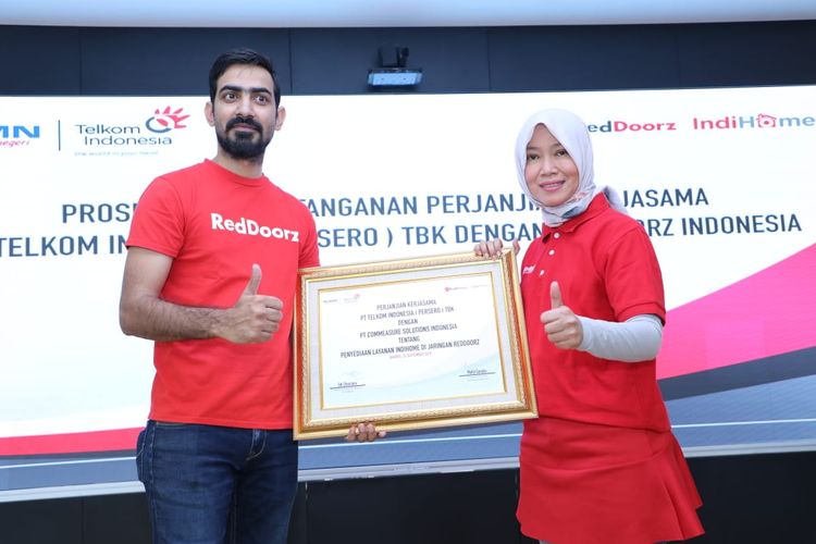 Direktur Consumer Service Telkom Siti Choiriana (kanan) bersama President Direktur RedDoorz Indonesia Mohit Gandas (kiri) usai penandatanganan kerja sama dalam penyediaan layanan IndiHome dan infrastruktur Local Area Network (LAN) di seluruh jaringan mitra penginapan dan hotel yang berafiliasi dengan RedDoorz, di Jakarta, Rabu (25/9/2019).