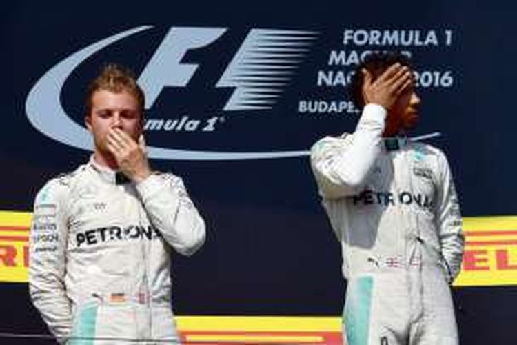 Dua pebalap Mercedes, Lewis Hamilton (kanan, Inggris) dan Nico Rosberg (Jerman), berdiri di atas podium setelah finis pertama dan kedua pada balapan GP Hongaria di Hungaroring, Minggu (24/7/2016).