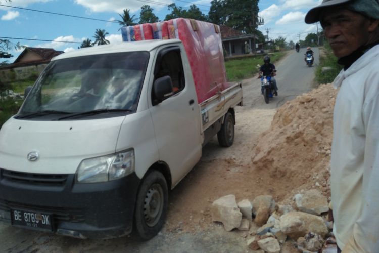 Kardiono (66) warga Tanjung Bintang yang swadaya menimbun lubang di jalan kecamatan tersebut, Kamis (11/2/2021).