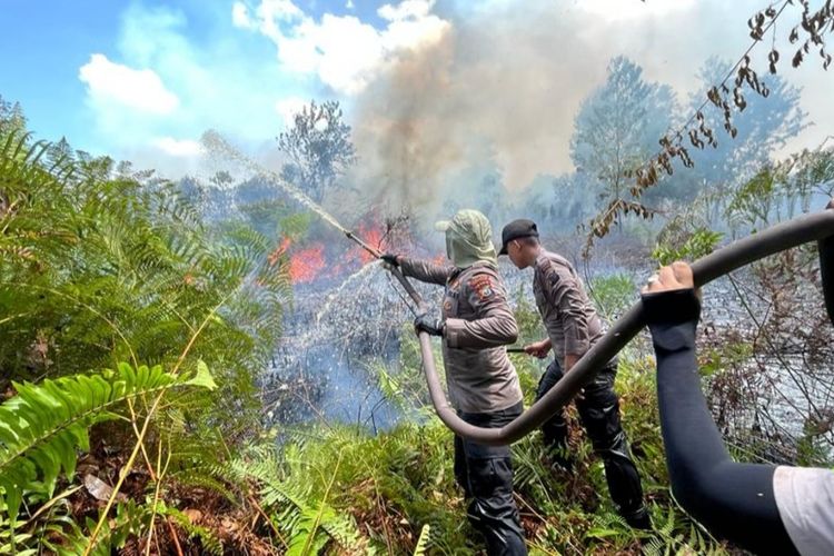 Petugas kepolisian berusaha memadamkan api kebakaran lahan gambut, di Desa Kembung Luar, Kecamatan Bantan, Kabupaten Bengkalis, Riau, Senin (20/3/2023).