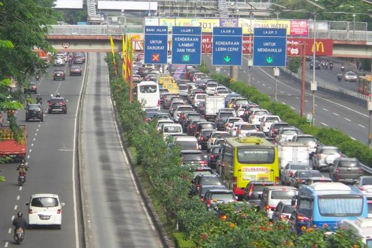 Kondisi jalan tol dalam kota (kanan) dari arah Cawang menuju Semanggi yang tengah dilanda kemacetan, Kamis (23/4/2015). Pada waktu yang sama, kondisi jalan reguler, yakni Jalan MT Haryono (kiri) justru tampak lengang. Hal ini kemungkinan besar karena sedang dilakukannya pengalihan arus di Jalan Gatot Subroto yang sedang digunakan delegasi peserta Konferensi Asia Afrika (KAA) melintas dari tempat penginapan ke lokasi tempat berlangsungnya acara di Jakarta Convention Center.