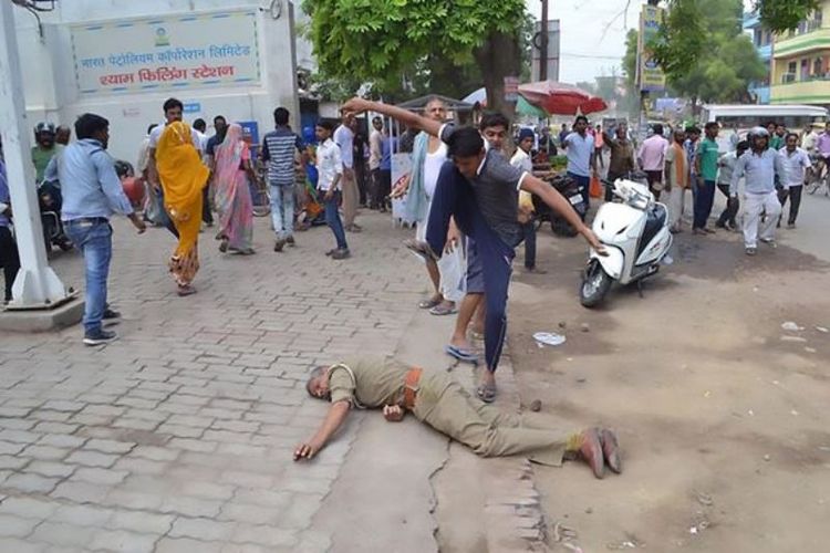 Salah seorang warga yang marah menginjak-injak seorang polisi saat menyerbu RS Jagriti di kota Kanpur, India setelah kabar pemerkosaan seorang gadis di ruang ICU merebak.