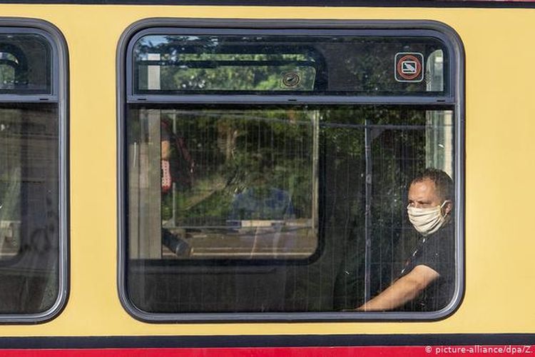 Seorang penumpang mengenakan masker di transportasi umum Berlin.