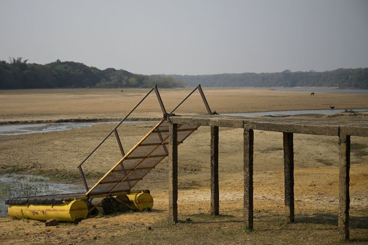The jetty of a fishing lodge is seen on the almost dry arm of the Parana River, which water level reached a historic low, near Itati, Corrientes, Argentina, on August 19, 2021. - The Parana River, which runs through Brazil, Paraguay and Argentina, the tenth largest river basin in the world, has reached its lowest water level in over half a century and it is an enigma whether it is a natural cycle or a result of climate change, with uncertain long-term effects. (Photo by JUAN MABROMATA / AFP)