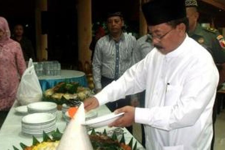 Wakil Bupati (Wabup) HMG Hadi Sutjipto memotong tumpeng saat rekonsiliasi partai untuk menyepakati perdamaian di pendopo kabupaten.