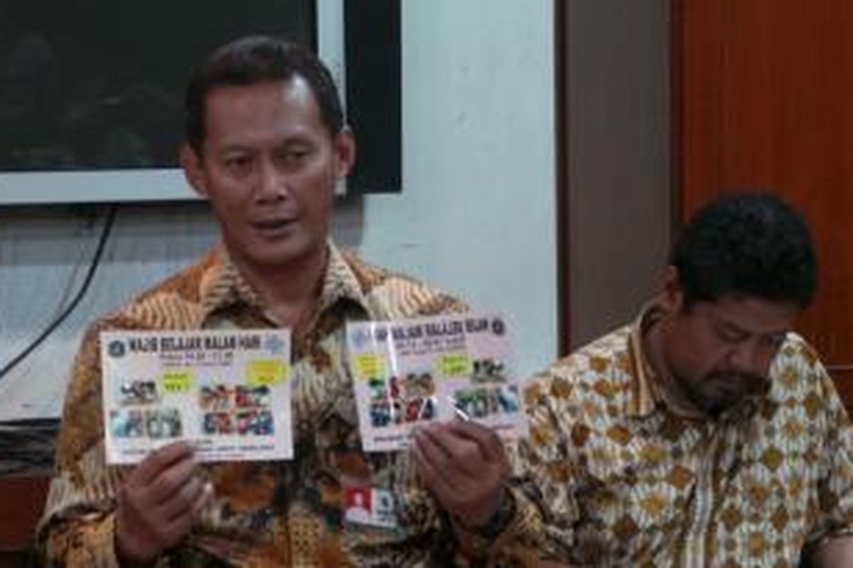 Kepala Dinas Pendidikan DKI Taufik Yudi Mulyanto, Jumat (1/11/2013), memperlihatkan stiker jam wajib belajar malam hari yang akan disebarkan di berbagai tempat di Jakarta.