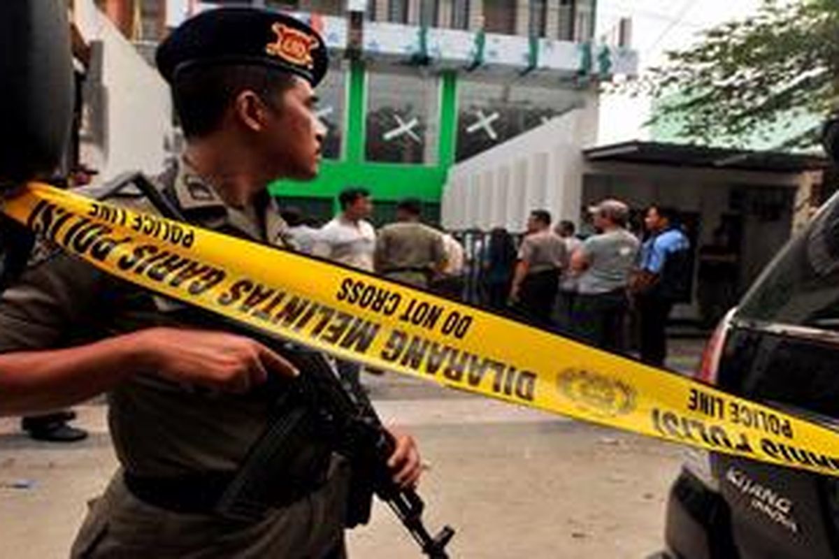 Polisi bersenjata lengkap berjaga-jaga saat  penggeledahan di sebuah bangunan di Medan, Sumut, Kamis (21/6/2012). Polisi menggeledah tiga rumah di Medan untuk mencari bukti terkait dugaan adanya jaringan terorisme di Medan.