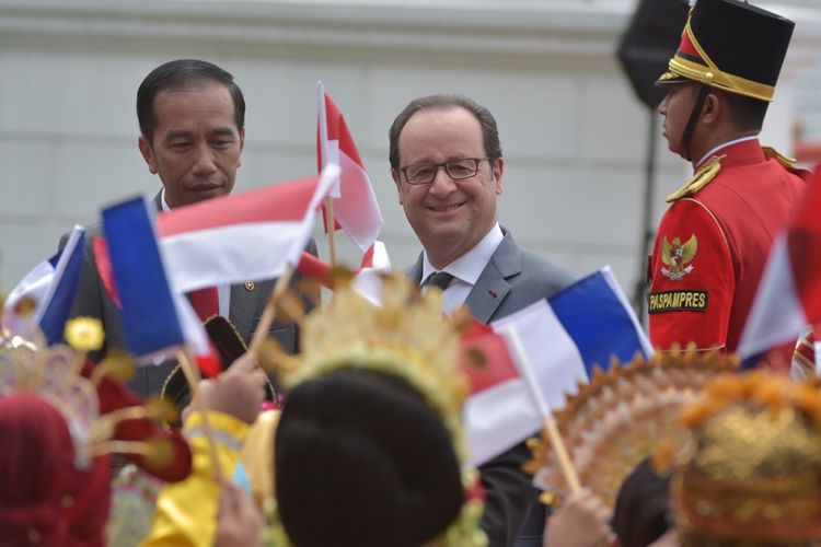 Presiden Perancis Francois Hollande (tengah) didampingi Presiden Joko Widodo menyaksikan sejumlah anak sekolah yang melambaikan bendera Perancis dan Indonesia, saat kunjungannya ke Istana Presiden di Jakarta, Rabu (29/3/2017). Kunjungan itu merupakan momen bersejarah sebab menjadi kunjungan pertama Presiden Perancis setelah 30 tahun.